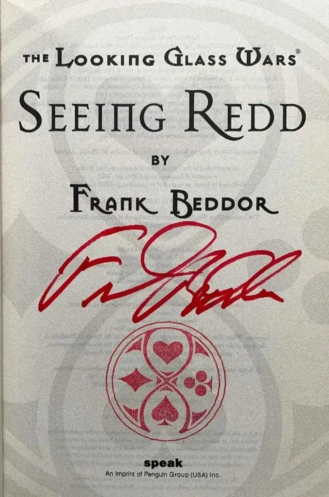 The title page signed in red ink by Frank Beddor above a red Wonderland seal.