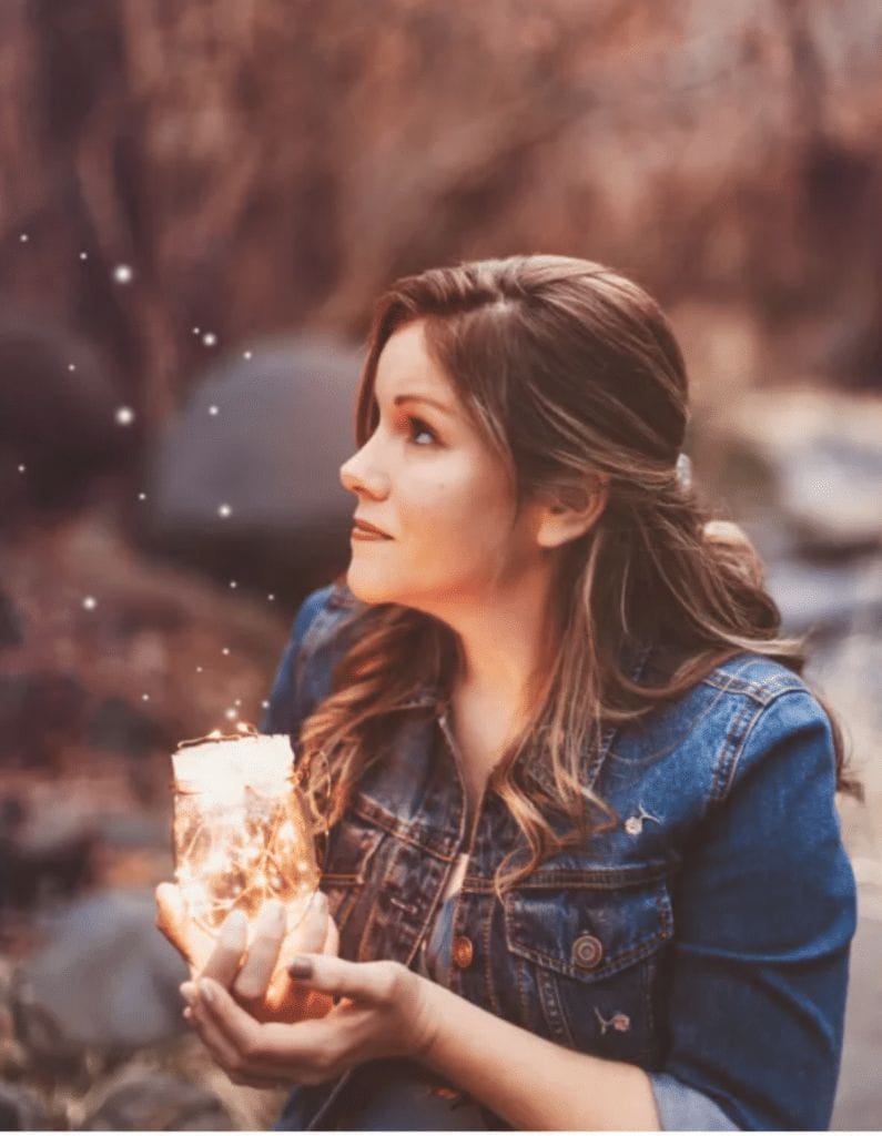Author Sara Ella holding a jar full of lights.
