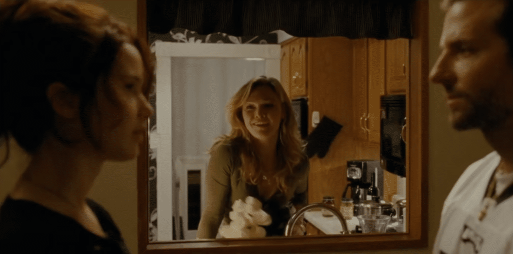 Still image of Julia Stiles, Jennifer Lawrence, and Bradley Cooper from the 2012 David O. Russell romantic dramedy film "Silver Linings Playbook".