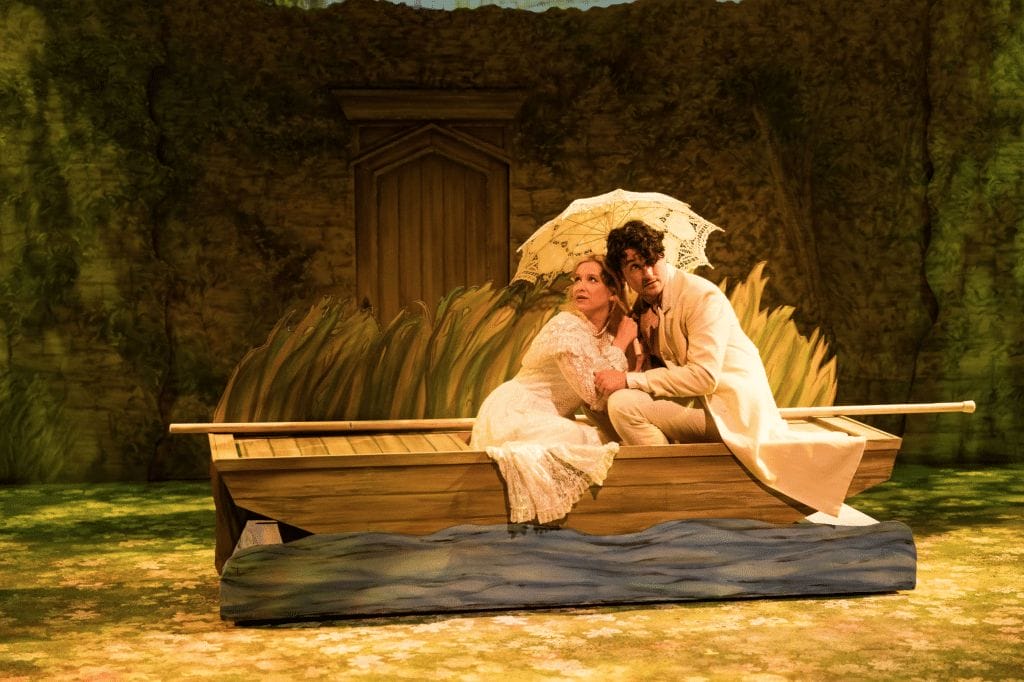 A still image featuring Alice Liddell and Prince Leopold in a rowboat from the production of the musical "Alice, Formerly of Wonderland".