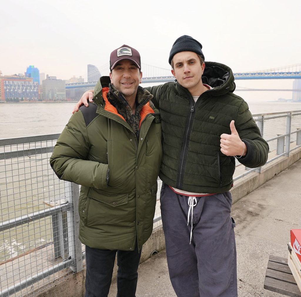 Image of actor David Schwimmer and artist MARKO with a river and bridge in the background.