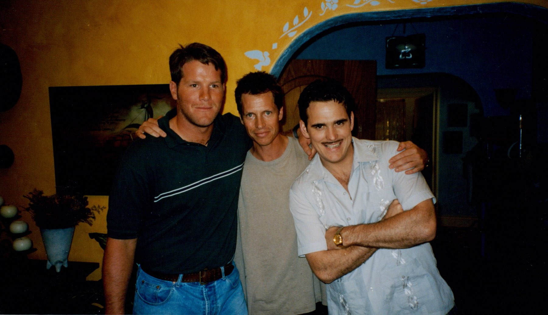 Frank Beddor on set with his arms round two others &mdash; Matt
                    Dillon on the right in Pat Healy&rsquo;s moustache and pale
                    shirt, and a third man on the left.
