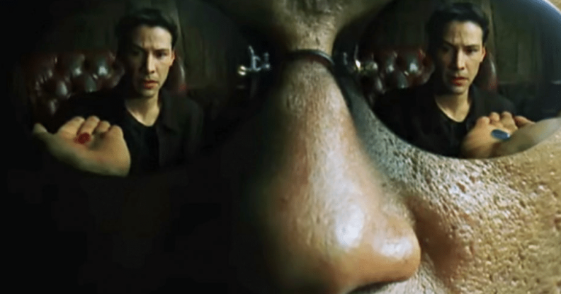 Image of Neo, from "The Matrix", played by Keanu Reeves. Reflected in the sunglasses of Morpheus, played by Laurence Fishburne, as he is choosing between the red pill, or the blue pill to go down the proverbial rabbit hole. 