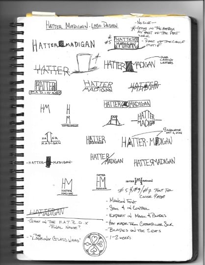 A spiral notebook with writing, and hand-drawn illustrations of potential logo design ideas for Hatter Madigan. 