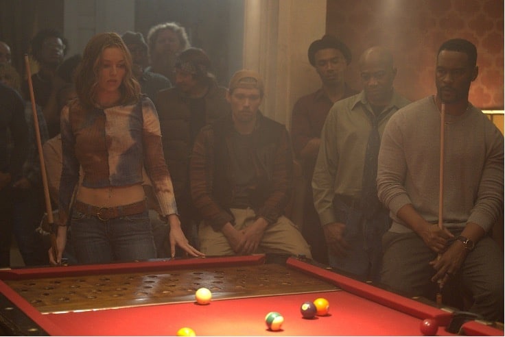 A gritty set photo from the new film Double Down South, directed by Tom Schulman. Lili Simmons sizes up a shot while playing Keno Pool surrounded by other players.