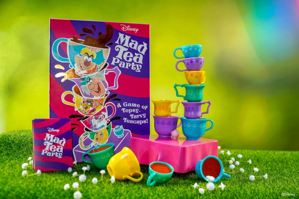 A picture of Disney's Mad Tea Party board game with a box and a toy tea set. Featuring iconic imagery of Walt Disney's classic 1951 animated film: Alice in Wonderland. 
