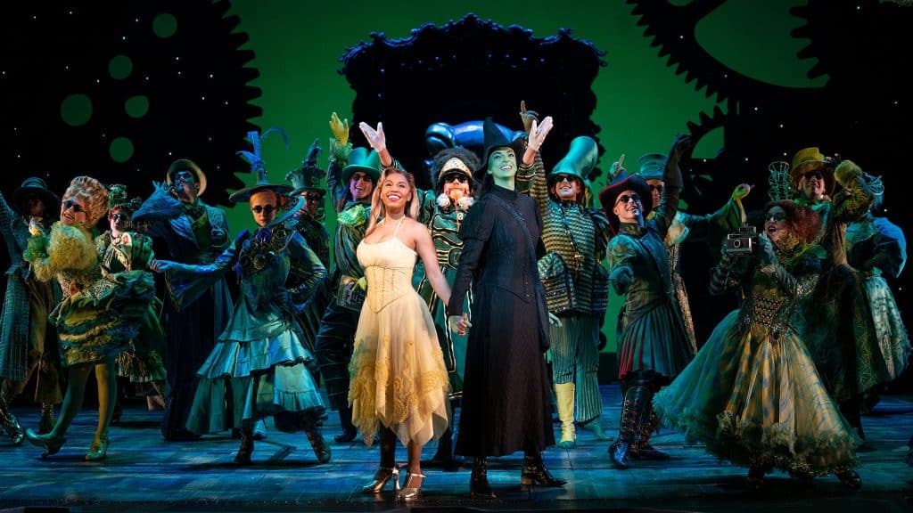 A photo of the broadway cast of Wicked The Musical posing at the end of a big number.