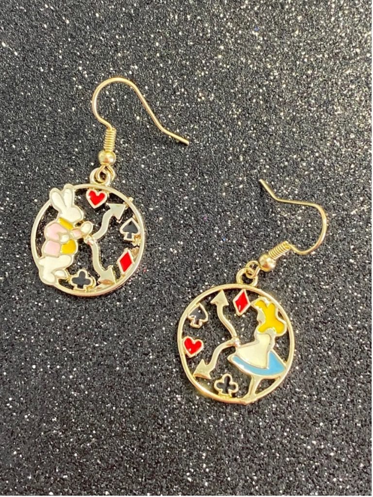 Colorful dangle earrings featuring Alice and the White Rabbit amid the suit symbols arranged like a clock