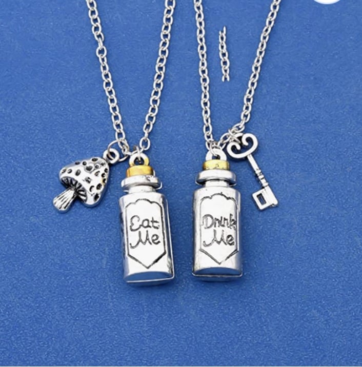 Charm necklaces with tiny silver bottles that read "eat me" and "drink me" small mushroom and key charms hang next to the bottles