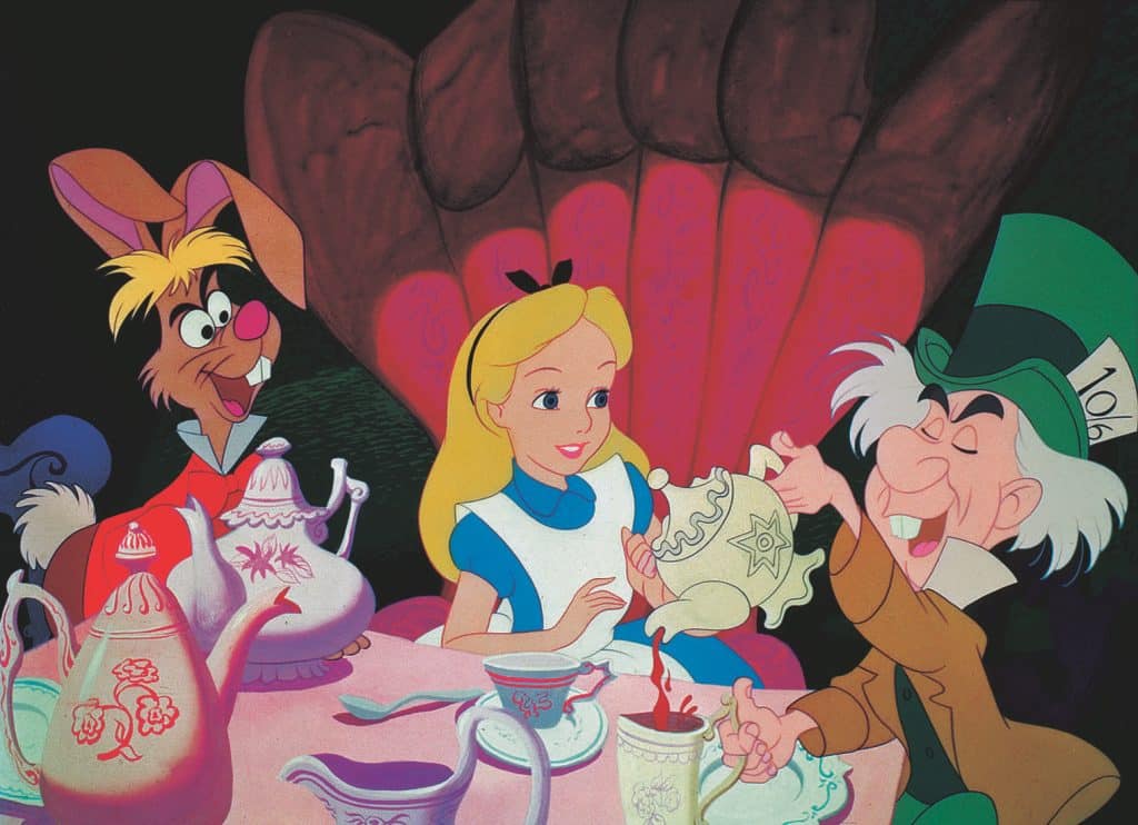 Alice, the March Hare, and the Mad Hatter at the Mad Hatter's tea party in "Alice in Wonderland"