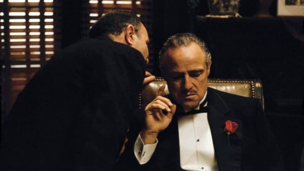 Amerigo Bonasera whispers in Vito Corleone's ear in a scene from the 1972 film "The Godfather". 