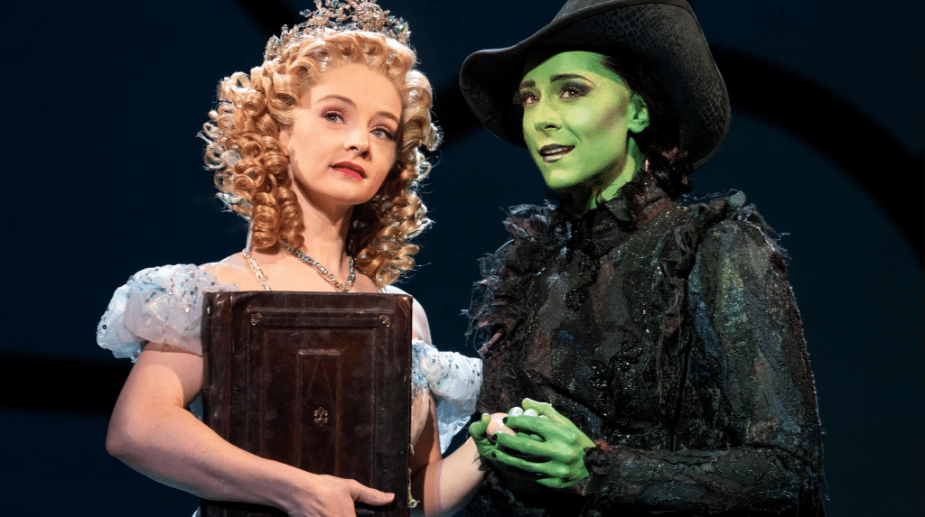 Glinda and Elphaba look off into the distance in a scene from the musical, "Wicked". 