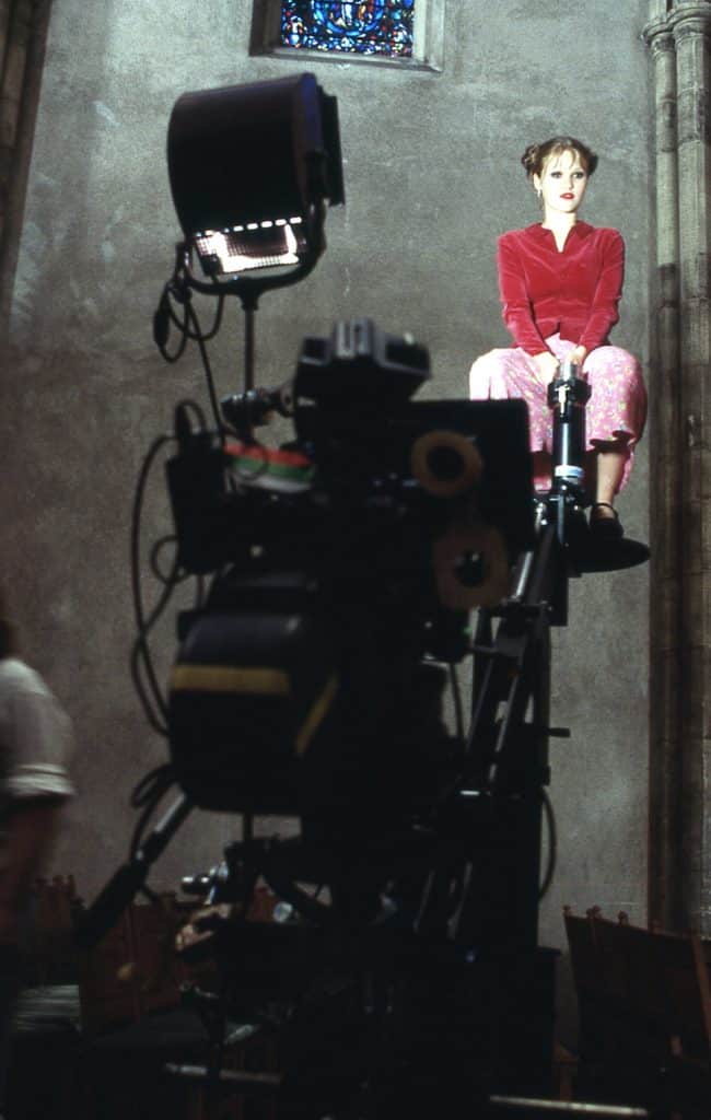 Behind-the-scenes photo of Julia Stiles sitting on a crane from the production of the 1998 thriller "Wicked". 