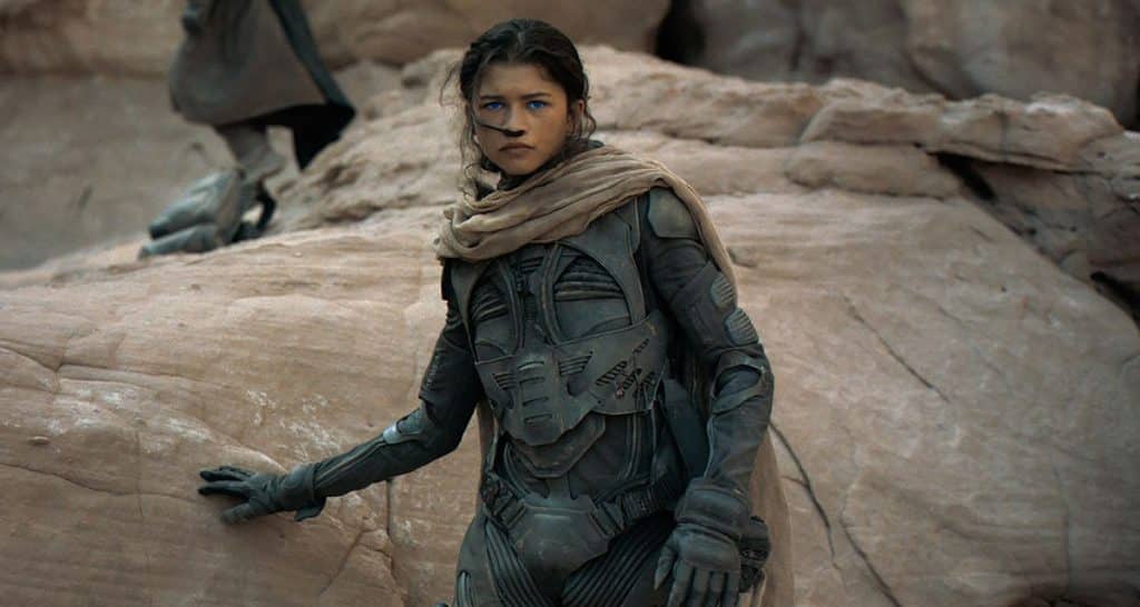 Still image of Zendaya as Chani, wearing an armored bodysuit and breathing tube, from the 2021 Denis Villeneuve film "Dune". 