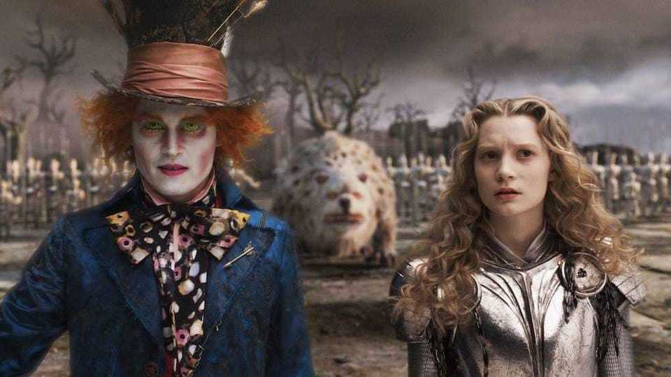 Still image of Johnny Depp as the Mad Hatter and Mia Wasikowska as Alice Kingsleigh standing in front of a beast and an army from the 2010 Tim Burton film "Alice in Wonderland". 