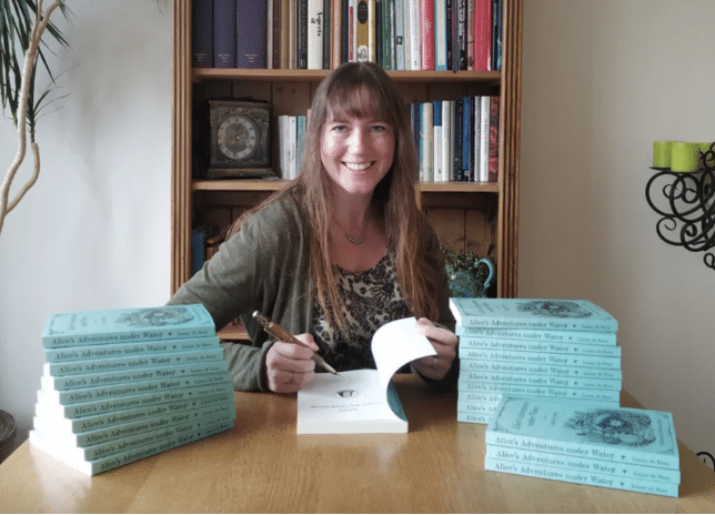 Author Lenny de Rooy signing copies of her book “Alice’s Adventures Underwater”.