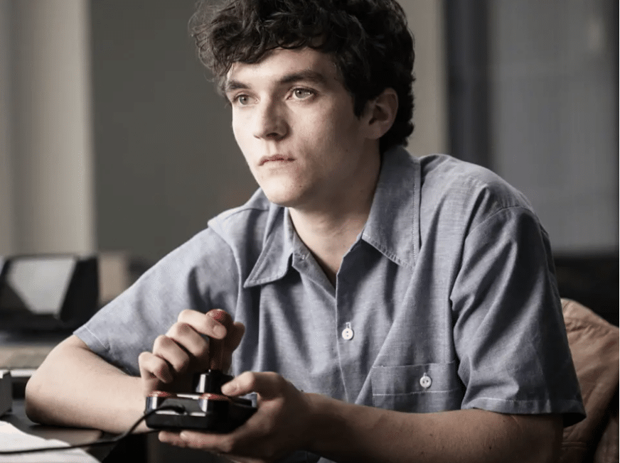 Still image of Fionn Whitehead as Stefan Butler playing a video game from the Netflix science fiction interactive film "Black Mirror: Bandersnatch".