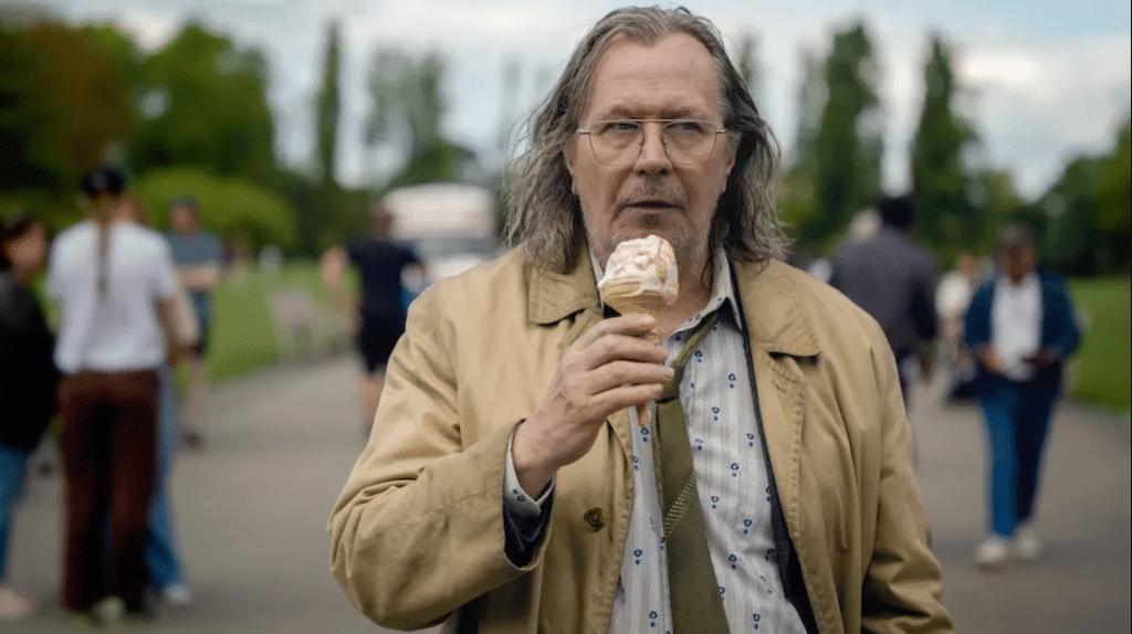 Still image of Gary Oldman as Jackson Lamb holding an ice cream cone from Season 3 of the Apple TV+ spy thriller series "Slow Horses", based on the "Slough House" series of novels by British author Mick Herron.