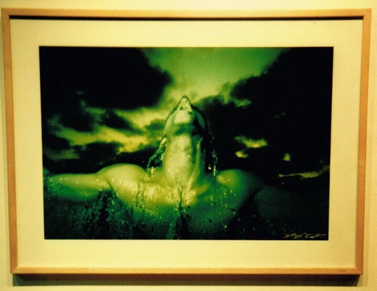 Photograph by Eshel Ezer of a man coming out of the water tinted in green. 
