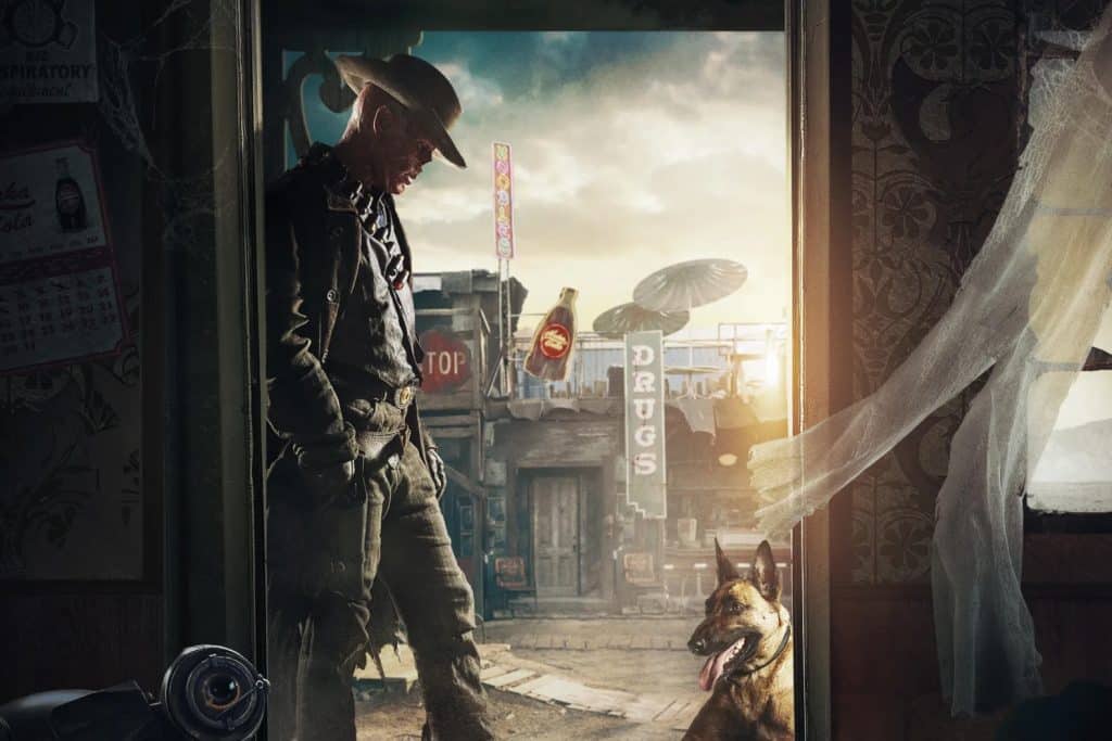 Promotional image from the Amazon post-apocalyptic drama series "Fallout" featuring Walton Goggins as The Ghoul/Cooper Howard and a German Shepherd dog with the town of Filly in the background.