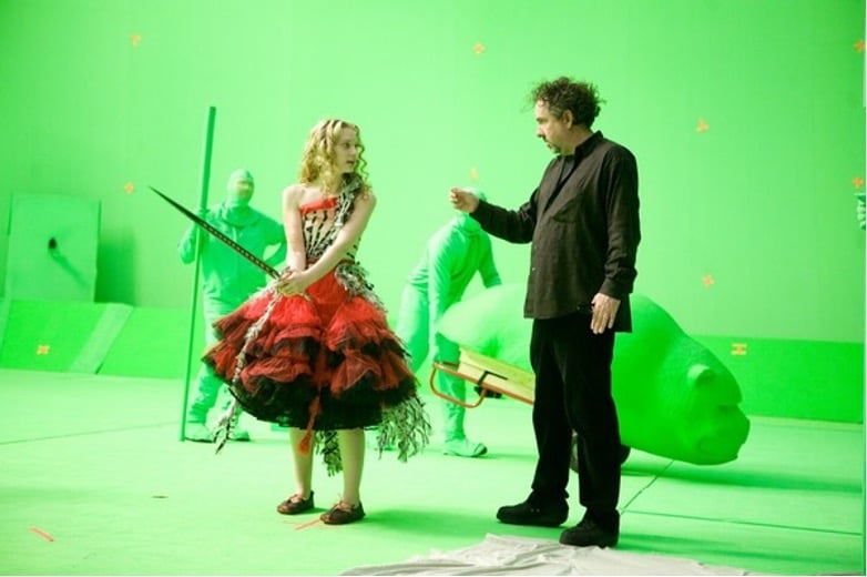 Behind-the-scenes image of Tim Burton and Mia Wasikowska on a green screen set during the production of the 2010 fantasy adventure film "Alice in Wonderland".