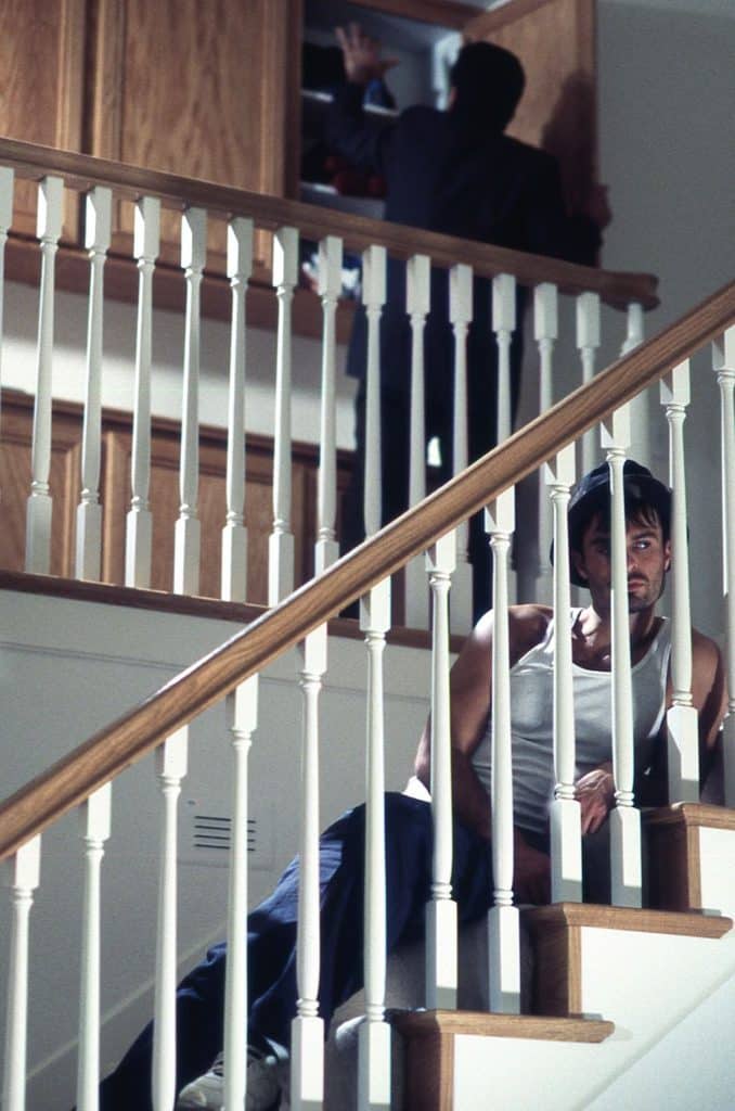 Photograph of actor Patrick Muldoon reclining on the stairs from the set of the 1998 thriller "Wicked". 