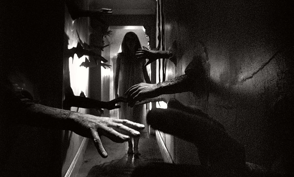 Black and white still image of Catherine Deneuve walking down a hallway with hands sticking out of the walls in the foreground from Roman Polanski's 1965 psychological horror thriller film "Repulsion". 