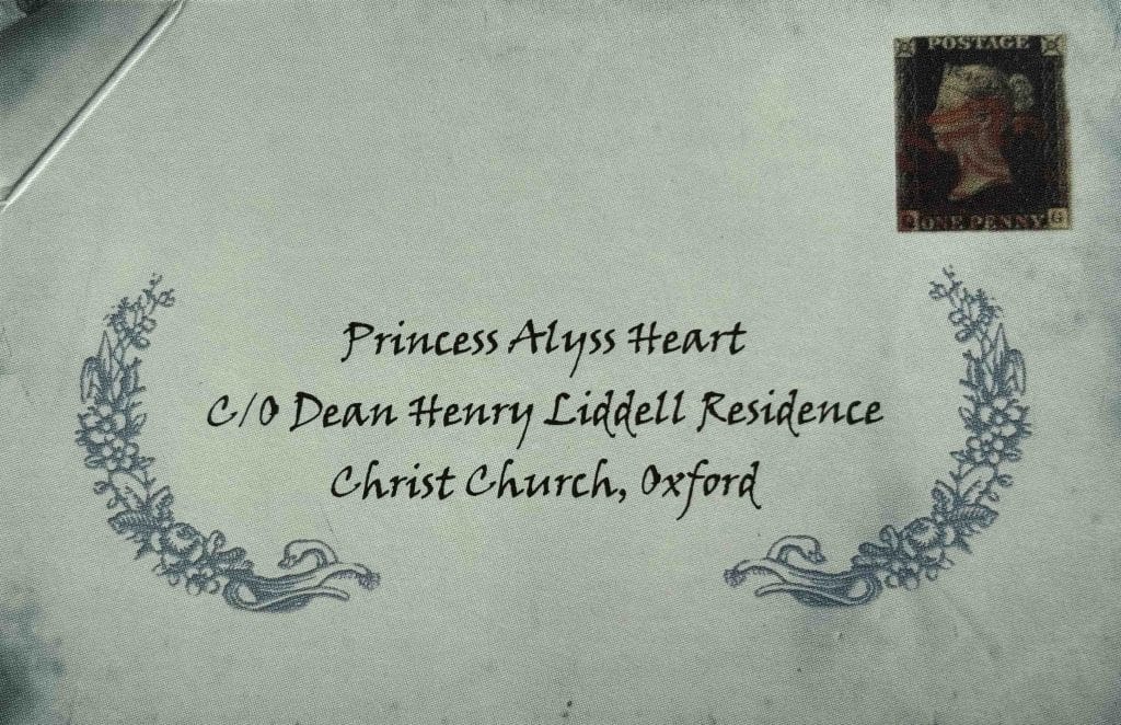 The front of a pale blue envelope addressed to "Princess Alyss Heart" with a stamp in the top right corner, produced for the book "Princess Alyss of Wonderland".   