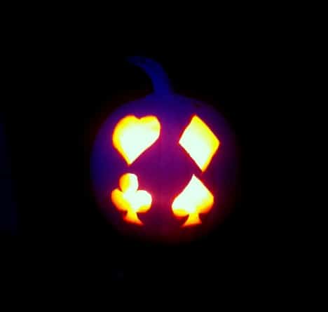 A photograph of a pumpkin carved with the four playing card suits. 