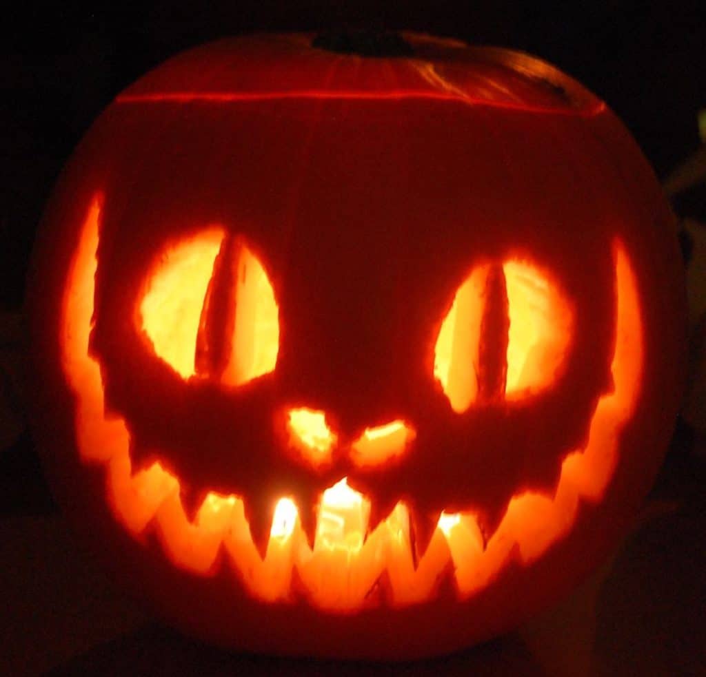 A photograph of a pumpkin carved to depict the Cheshire Cat from "Alice in Wonderland". 