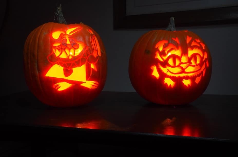 A photograph of a pumpkin carved to depict the White Rabbit and the Cheshire Cat from "Alice in Wonderland". 