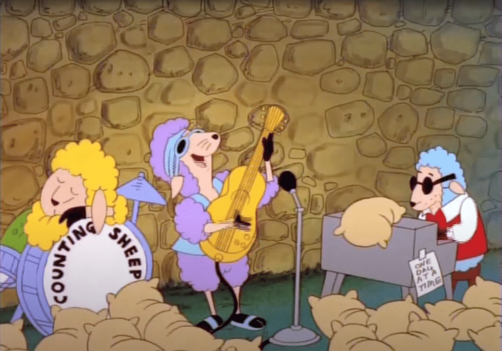 Screenshot of the animated children's TV show "The Blanket Show," featuring a band of sheep playing against a wall and surrounded by pillows. 